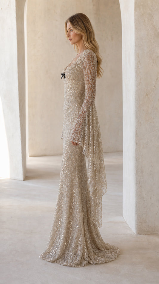 Side profile view of champagne sequin floor-length evening gown showcasing bell sleeve drape