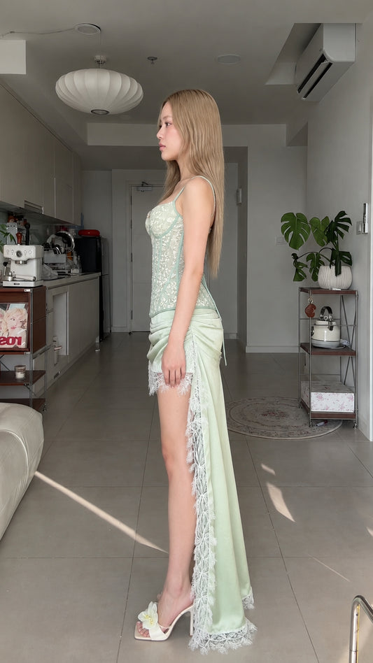 Side profile of sage green lace corset top and asymmetrical draped skirt