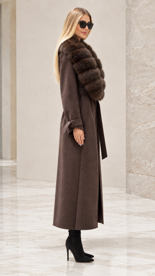 Side profile of woman wearing brown belted maxi coat with faux fur trim